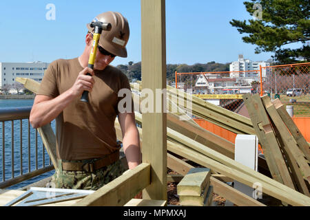 170405-N-XN177-035 Yokosuka, Giappone (5 aprile 2017) - Builder 2a classe Scott Klugh, da Pittsburgh, martelli un chiodo in un asse di legno per la nuova passerella a bordo le attività della flotta (FLEACT) Yokosuka. FLEACT Yokosuka fornisce, mantiene e gestisce servizi di base e servizi a sostegno del settimo della flotta di inoltro distribuito le forze navali, 71 comandi tenant e 26.000 militari e civili. (U.S. Foto di Marina di Massa lo specialista di comunicazione 1a classe Pietro Burghart/rilasciato) Foto Stock