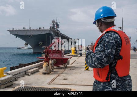 170406-N-XT039-098 Okinawa, in Giappone (6 aprile 2017) macchinista compagno del 3° di classe Gary Benson, da Atene, Ga., assegnato al comandante, le attività della flotta Okinawa (CFAO) operazioni portuali, esegue la movimentazione della linea funzioni come l'assalto anfibio nave USS Bonhomme Richard (LHD 6) pierside arriva alla spiaggia bianca di struttura navale di sbarcare Marines del trentunesimo Marine Expeditionary Unit. Bonhomme Richard, ammiraglia del Bonhomme Richard anfibio gruppo pronto, è su una pattuglia, operando in Indo-Asia-regione del Pacifico per migliorare la prontezza combattimento e la postura in avanti come una pronta risposta in vigore per qualsiasi tip. Foto Stock