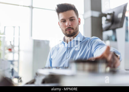 L'uomo esaminando prodotto in azienda Foto Stock