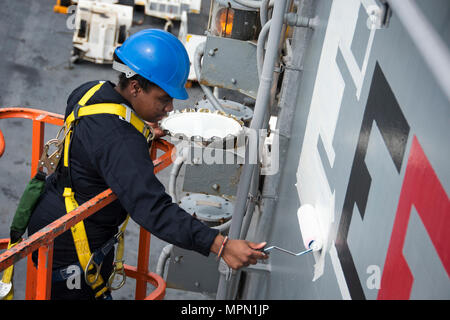 170406-N-WF272-151 spiaggia bianca, Okinawa (Aprile 6, 2017) Quartermaster marinaio Daija Anderson, da Houston, dipinge una "E" sulla sovrastruttura dell'assalto anfibio nave USS Bonhomme Richard (LHD 6) per indicare il comando's 2017 Battaglia efficacia Award (Battaglia "E"). La superficie navale il comando delle forze (COMSURFOR) battaglia "E" il premio viene assegnato ogni anno ai migliori navi nell'Atlantico e nel Pacifico flotte e che riconosce un comando prolungato di prestazioni superiori. Bonhomme Richard, ammiraglia del Bonhomme Richard anfibio gruppo pronto, è su una pattuglia, operando in Indo-Asia-regione del Pacifico Foto Stock