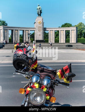 Berlin Mitte, bici del motore particolare. Moto parcheggiata con tedesco bandiere, casco & cranio a fronte di guerra sovietica Memorial presso Bikers Demo. Foto Stock