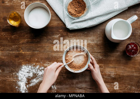 Ritagliato shot della donna la preparazione di liquido per la cottura frittelle sul tavolo di legno Foto Stock