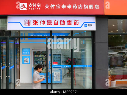 (180524) -- ZHENGZHOU, 24 maggio 2018 (Xinhua) -- Un cittadino passeggiate passato un "futuro farmacia' in Zhengzhou, capitale della Cina centrale della Provincia di Henan, 24 maggio 2018. Un "futuro farmacia' di Alipay aperto qui il giovedì, che permette di affrontare la scansione a pagamento, remoto consulenza sani, richiesta prenotazione, 24 ore di self-service di vendita di droga e altri servizi. (Xinhua/Feng Dapeng) (zwx) Foto Stock