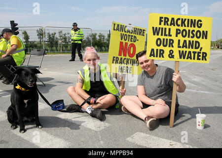 Due Anti-Fracking manifestanti con cartelli e il loro cane troppo, stadio a sedersi protesta alle porte dell'azienda Fracking 'Cuadrilla's" Frack sito durante una tranquilla giornata di continuare la protesta. Cuadrilla hanno applicato per un'estensione e modifica di un provvedimento inibitorio per rendere protestando per il loro sito illegale. Foto Stock