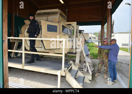 Giuseppe Gallegos, specialista della formazione, supporto di formazione nel centro Italia, mostra la elevata mobilità multiuso di veicolo su ruote (HMMWV) assistenza egress trainer (calore), a Sgt. Il Mag. Massimo Giordano esercito italiano, durante la formazione dei Carabinieri italiani del 7° Reggimento Carabinieri "Laives" Bolzano e xiii reggimento Carabinieri "Friuli Venezia Giulia Gorizia, presso Caserma Ederle, Aprile 6, 2017, Vicenza, Italia. Il simulatore consente ai soldati di pratica uscire dai veicoli, di competenze e di impegnarsi in scenari realistici. Uso dei Carabinieri U.S. RTSD esercito sud attrezzatura per migliorare le relazioni bilaterali e Foto Stock