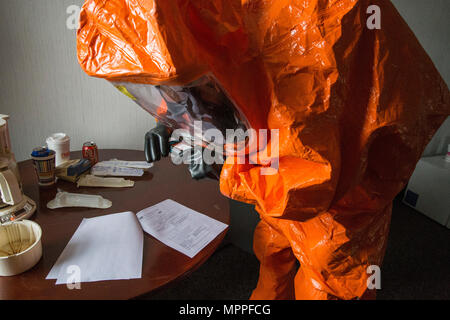 Il personale Sgt. Nicky Lam con il New Jersey Guardia Nazionale della ventunesima armi di distruzione di massa supporto Destruction-Civil Team, fotografie prove reperite presso un laboratorio simulato sito durante una formazione congiunta di esercitare con membri del Monmouth County Hazmat Team a Fort Monmouth, N.J., Aprile 6, 2017. Il ventunesimo WMD-CST è una unità di snodo compreso del New Jersey e la Guardia Nazionale di soldati e aviatori la cui missione è quella di sostenere le autorità civili identificando chimici, biologici, radiologici e nucleari in sostanze artificiali o calamità naturali. (New Jersey Guardia Nazionale foto di Marco C. Olsen/rilasciato) Foto Stock