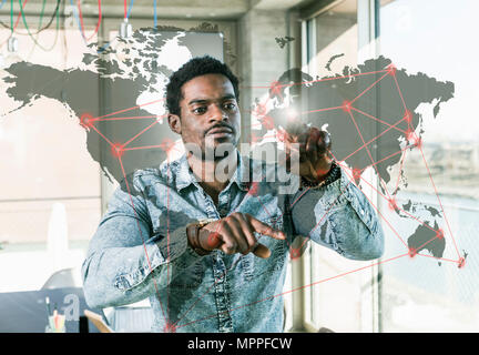 Casual uomo d affari di toccare il riquadro del vetro con la mappa del mondo in carica Foto Stock