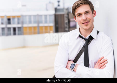 Ritratto di imprenditore sorridente indossando smartwatch Foto Stock