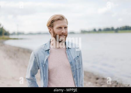 Germania, Duesseldorf, ritratto di uomo sorridente al Riverside Foto Stock