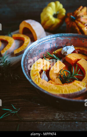 Fette di zucca, aglio e rosmarino in casserolle Foto Stock