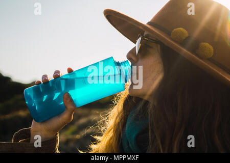 Donna su una escursione da bere acqua in bottiglia Foto Stock