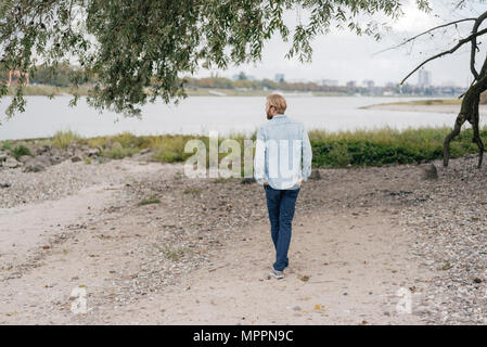 Germania, Duesseldorf, vista posteriore dell uomo in piedi sulla spiaggia Foto Stock