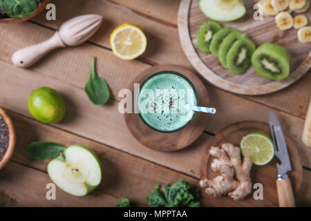 Frullato di verde circondato da ingredienti Foto Stock