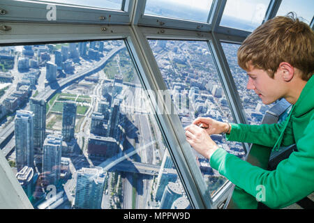 Toronto Canada, Bremner Boulevard, CN Tower, osservazione meraviglia moderna, Sky Pod, vista della finestra ovest, ragazzo teen, prendendo urbano, vista aerea dall'alto da abov Foto Stock