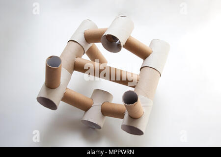 Costruzione astratta progettato con beige carta cartone tubi isolati su sfondo bianco Foto Stock