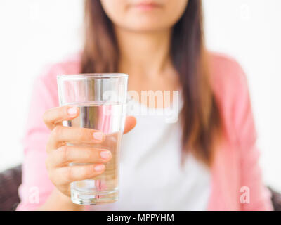 Un bicchiere di acqua minerale pulita nella donna con le mani in mano. Concetto di tutela dell'ambiente, bibita salutare. Foto Stock