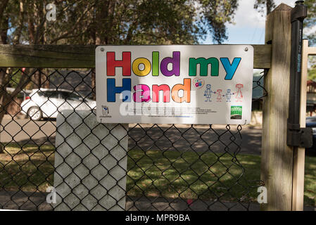 A tenere la mia mano segno in un parco in uscita Ku-Ring-gai su Sydney North Shore. Questa è una strada iniziativa di sicurezza per proteggere i bambini sotto i dieci anni di età. Foto Stock