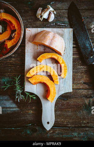 Fette di zucca su pannello di legno Foto Stock