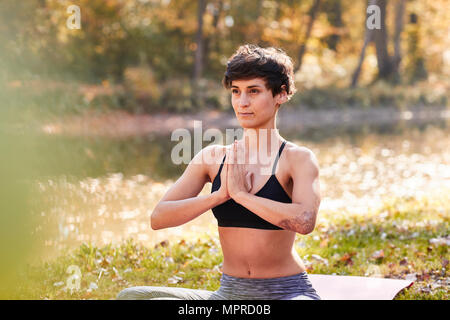 Metà donna adulta nella foresta a praticare yoga e meditazione Foto Stock
