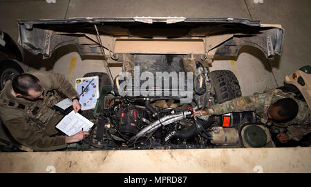 Senior Airman Michael Ripple, 791st Missile delle forze di sicurezza risposta squadron leader di forza e Staff Sgt. Calvin Smith, 91Missile forza di sicurezza volo squadrone controller di sicurezza, ispezionare il motore di un Humvee a Minot Air Force Base, N.D., Marzo 28, 2017. Per garantire una longevità di veicoli, aviatori esegue un controllo approfondito prima di andare al campo. (U.S. Air Force foto/Airman 1. Classe Austin M. Thomas) Foto Stock