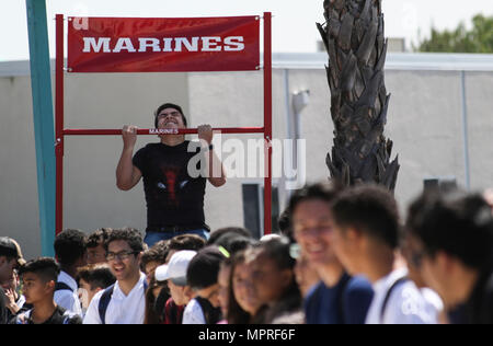 Uno studente di Olympian High School, Chula Vista, California, esegue come molti pull-up come egli può guadagnare premi dal pull-up sfida durante l'anti-bullismo ASA tour, 4 aprile 2017. Marine Corps reclutatori da San Diego, ASA divertimento personale e professionale i piloti di BMX viaggiato di più scuole, aprile 3-7, 2017, per la diffusione di anti-bullismo consapevolezza e insegnare agli studenti come fare per prevenire e reagire a differenti tipi di bullismo. (U.S. Marine Corps foto di Sgt. William Hester/ rilasciato) Foto Stock