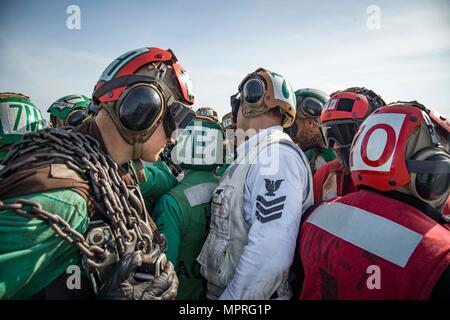 170412-N-OS569-101 OCEANO ATLANTICO (12 aprile 2017) velisti assegnati per il polveroso cani di elicottero di mare squadrone di combattimento (HSC) 7 huddle insieme per celebrare dopo il completamento di un fly-off evoluzione sul ponte di volo della portaerei USS Dwight D. Eisenhower CVN (69) (IKE). Ike e la sua portante strike gruppo sono in corso partecipano in un esercizio di supporto progettati per mantenere la disponibilità di distribuzione come parte della flotta ottimizzato il piano di risposta (OFRP). (U.S. Foto di Marina di Massa Specialista comunicazione marinaio Zach Sleeper) Foto Stock