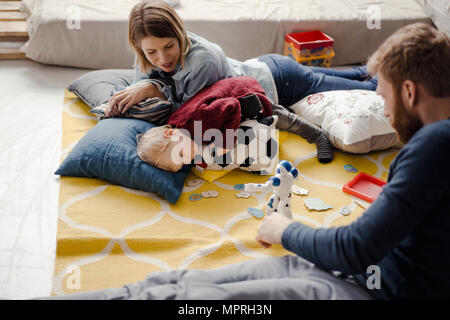 La famiglia felice giocando con il loro figlio a casa Foto Stock