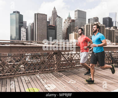 Stati Uniti d'America, New York City, due uomini in esecuzione su Brooklyn Brige con dati sul terreno Foto Stock