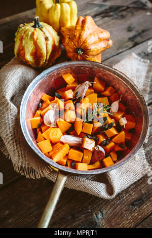 Dadini di zucca, aglio, rosmarino e i semi di zucca in casserolle Foto Stock