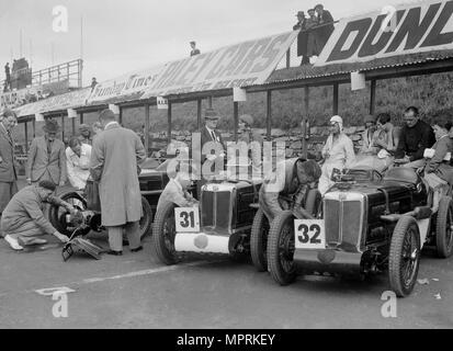 Tre MG C Type Midgets ai box al RAC TT race, circuito di Ards, Belfast, 1932. Artista: Bill Brunell. Foto Stock