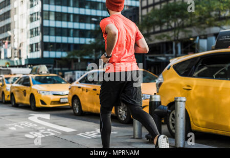 Stati Uniti d'America, New York City, l'uomo in esecuzione nella città con i dati sul marciapiede Foto Stock