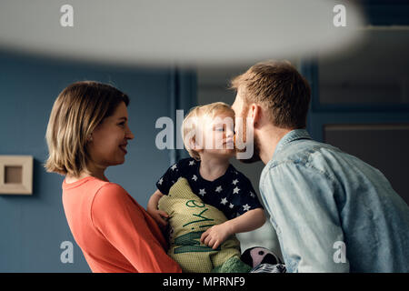 La famiglia felice giocando con il loro figlio a casa Foto Stock