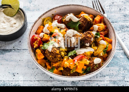 Ciotola vegetariano con dolce di patata e di pomodoro e i falafel, yogurt dip e prezzemolo Foto Stock