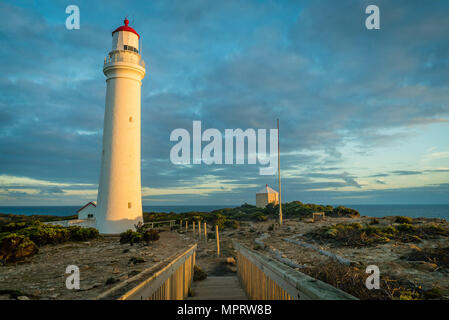 La luce del tramonto su una di colore rosso e bianco faro di Cape Nelson parco dello stato Foto Stock