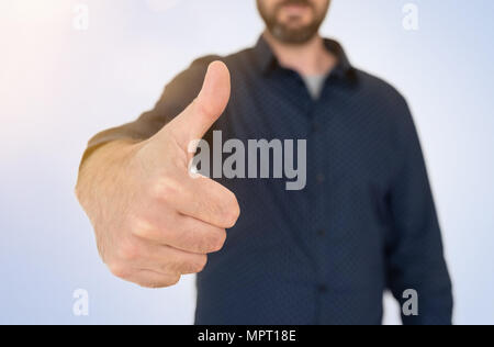 Imprenditore in maglietta blu che mostra Thumbs up gesto Foto Stock