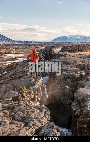 L uomo sta a livello continentale spaccatura tra Nord America e piastra eurasiatica, Mid-Atlantic Ridge, Rift Valley, Silfra Rift, Krafla Foto Stock