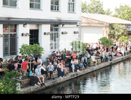 Persone bere e godersi il sole al di fuori della cassa Brewery Bar e Pizzeria, Hackney Wick, East London Foto Stock