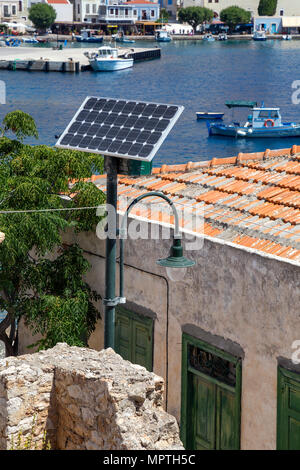 Pannello solare alimentato da una cella a luce di strada con baia mare sullo sfondo di un'isola greca di Halki presso il Mare Egeo. Foto Stock