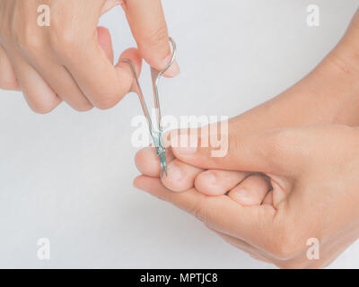 Closeup attraente giovane donna il taglio i suoi piedi unghie. La cura per la salute e la bellezza del concetto. Foto Stock