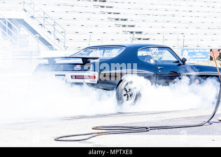 Muscle car eseguendo un burnout in pista Foto Stock