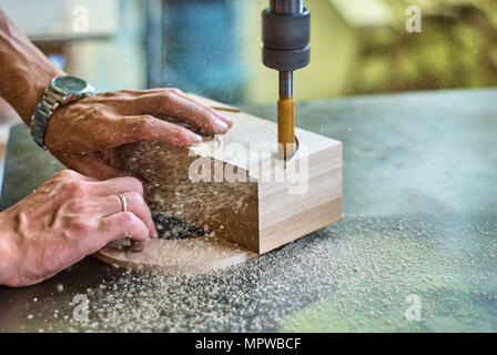 Trasformazione di prodotti in legno con una macchina di fresatura in un laboratorio di falegnameria Foto Stock