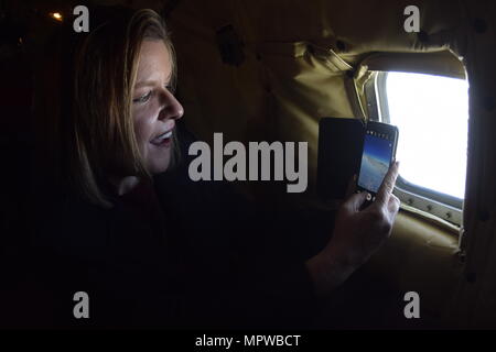 Debra Toufel, Università di Oklahoma Prezzo College of Business Director di partenariati pubblico-privato e membro della Tinker Air Force Base comandante onorario della classe 2017 prende una foto attraverso la finestra di fusoliera di un KC-135R Stratotanker durante una formazione locale volo Aprile 6, 2017 da Tinker Air Force Base in Oklahoma. Il comandante onorario è imparato circa la missione della 507th Air Refuelling Wing, Air Force comando Reserve, durante un rifornimento di aria la missione con F-16 Fighting falchi della 138th Fighter Wing, Oklahoma Air National Guard. (U.S. Air Force foto/Greg L. Davis) Foto Stock