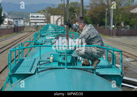 Il 19 aprile 2017 presso la base aerea di Yokota, Giappone documenta un ufficiale non commissionato del laboratorio 374th Logistics Readiness Squadron Fuels restituendo carburante JP8 a un carro armato dopo un'ispezione visiva. L'immagine di archivio registra i controlli di contaminazione eseguiti per rilevare acqua o altre sostanze estranee nel carburante per aviazione. Foto Stock