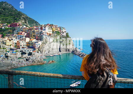 Una sola donna ammirare la splendida vista della città di Manarola. È uno dei cinque famosi villaggi colorati del Parco Nazionale delle Cinque Terre in Italia. Manarola, Foto Stock