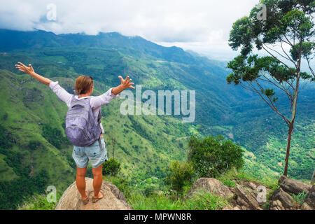 Caucasian woman standing e guardando sulla montagna e valle. Foto Stock