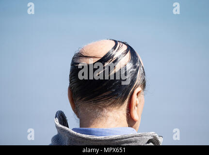 Vista posteriore di balding eldery uomo con pettine su Foto Stock