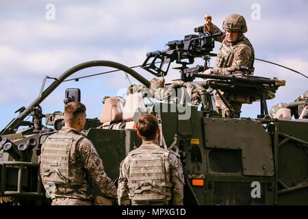 U.K. soldato dell'esercito assegnato per primo la regina Dragoon Guards (in alto a destra), soldati insegna come utilizzare un L134A1 Granata Mitragliatrice durante il primo dei quattro giorni di addestramento alle armi evento con il gruppo di combattimento della Polonia a Bemowo Piskie Area Formazione, Polonia, il 15 maggio 2018, 15 maggio 2018. Gruppo di combattimento della Polonia è un luogo unico e multinazionale di coalizione di Stati Uniti U.K. Il croato e soldati rumeni che servono con il polacco della XV Brigata meccanizzata come una forza di dissuasione a sostegno della NATO in avanti rafforzata presenza. (U.S. Esercito foto di Spc. Hubert D. Delany III /22 Mobile degli affari pubblici distacco) immagine Foto Stock