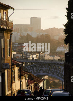 Bel colore arancione tramonto ponte dal Porto tra alcuni edifici Foto Stock