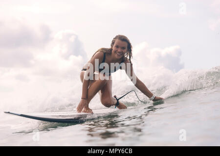 Ritratto di spensierata donna sorridente surf in mare Foto Stock