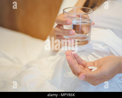 Close up della donna prendendo in pillole con il fuoco selettivo. Medicina, sanità e concetto di persone. Foto Stock